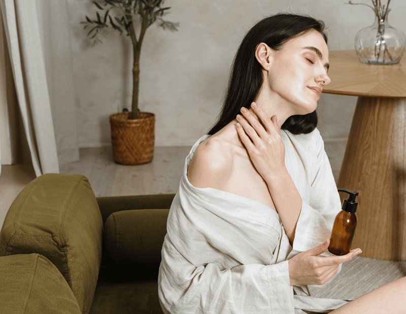 Woman applying topical magnesium lotion during a calming self-care routine for stress relief