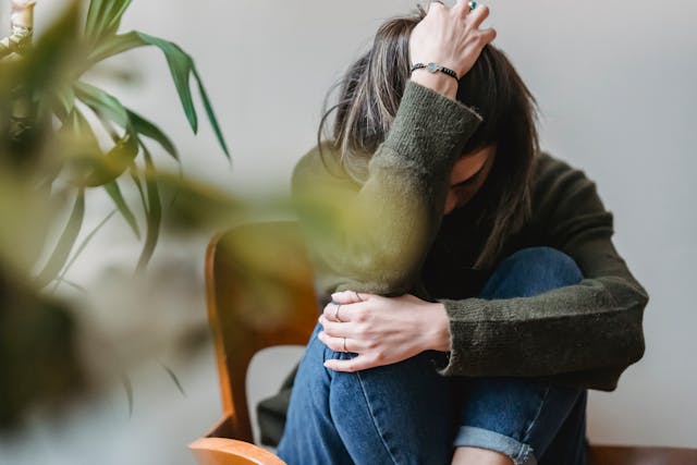 Woman sitting on floor head in hand