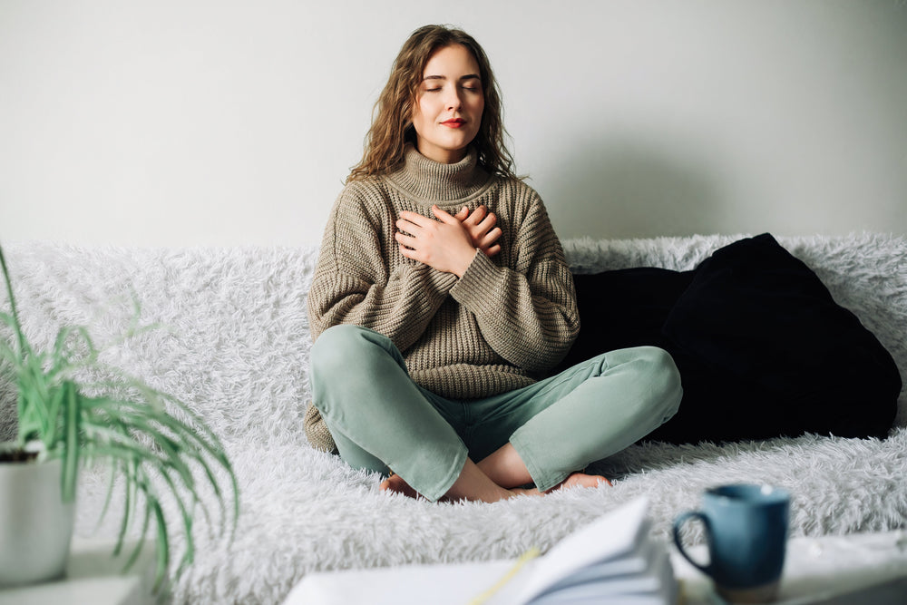 women sitting on couch practicing relaxation technique