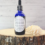 Bottle of ImmunoArmor tincture displayed with astragalus, echinacea, nettle, and lemon balm.