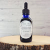 Pure Vitality herbal tincture photographed on a natural background with adaptogenic herbs.